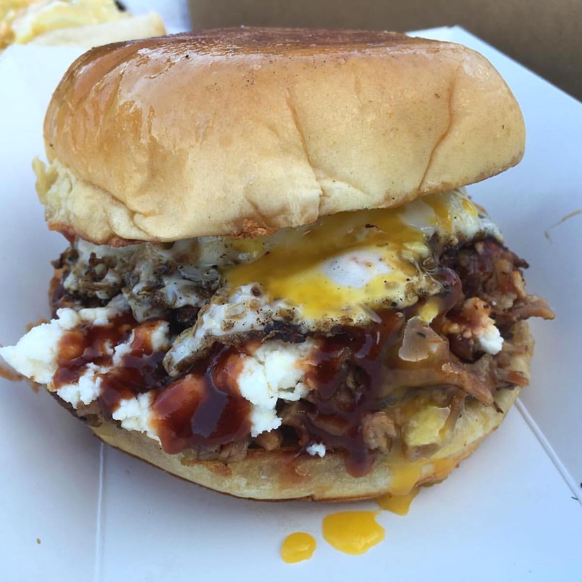 King of Rack's Brisket Sandwich with housemade BBQ sauce, feta cheese, onions and egg